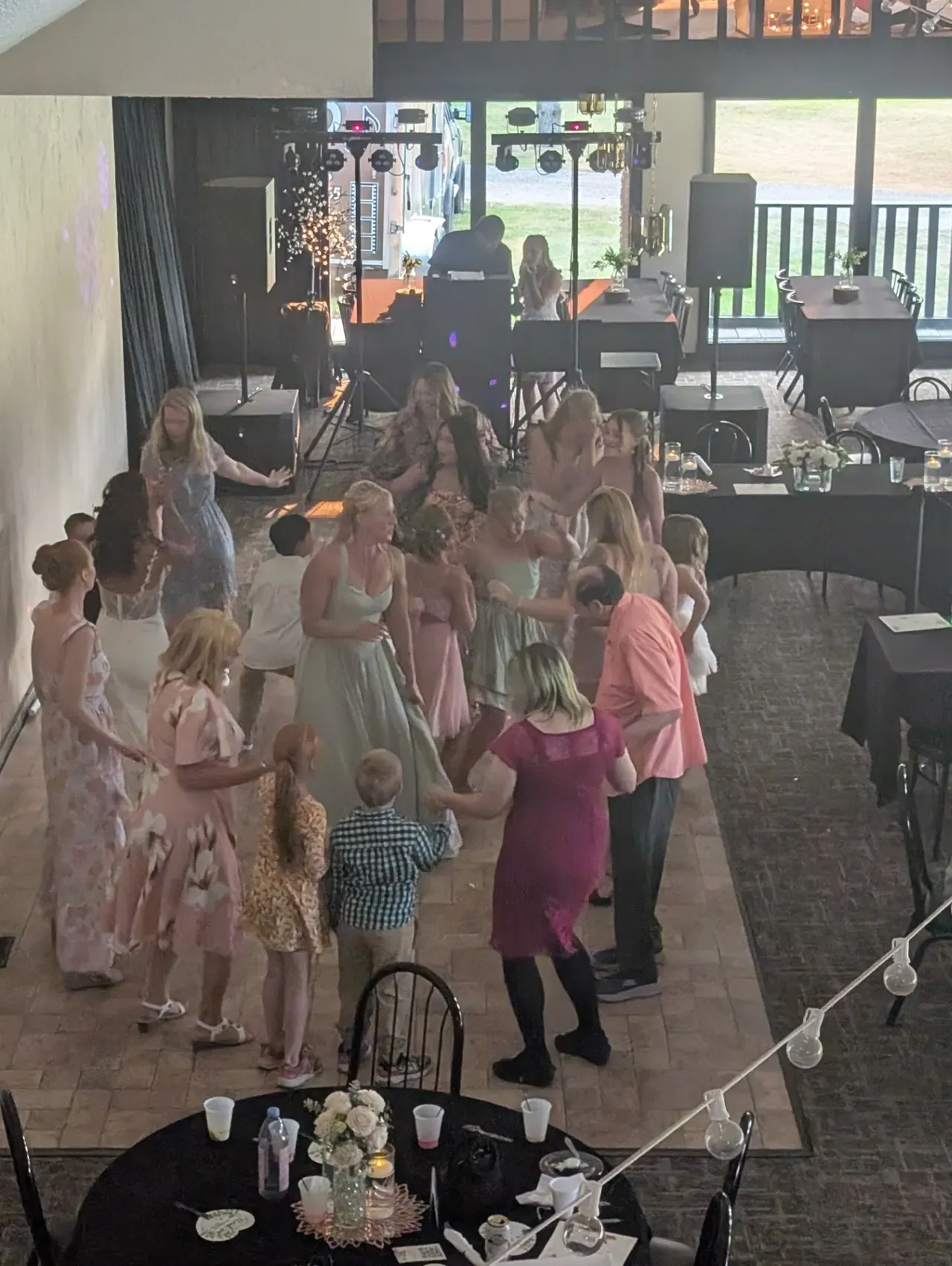 A crowded wedding dance floor, guests seen from behind